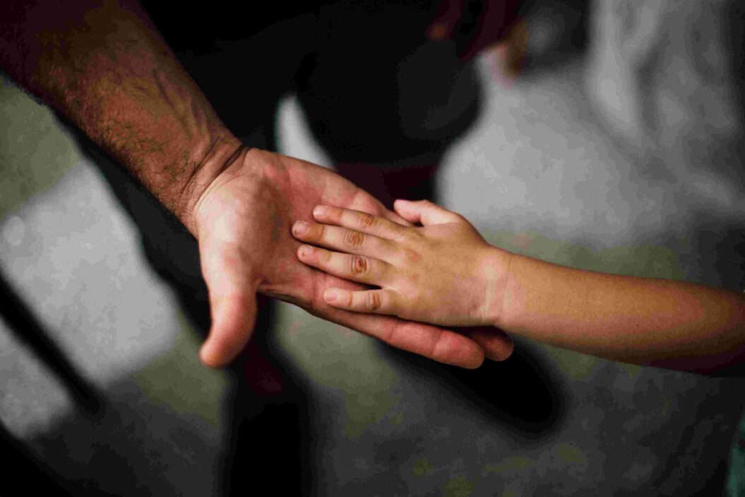 Hands of a kid and an adult