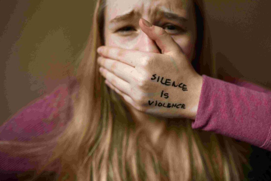 A woman in fear placing her hand on her lips